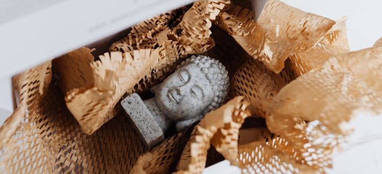 A granite Buddha bust in a cardboard package