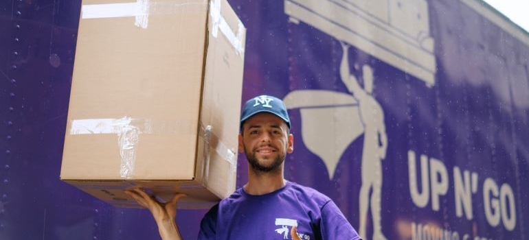A man is holding a cardboard box.