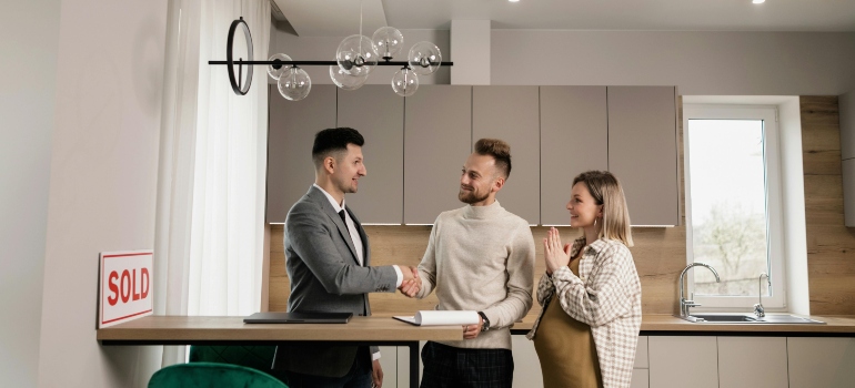 A couple celebrates with their agent after finalizing their apartment hunting in Soho.