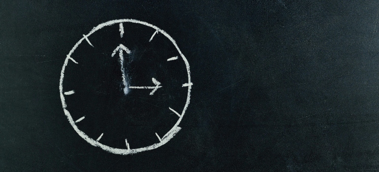 Chalkboard drawing of a clock, highlighting the importance of careful scheduling.
