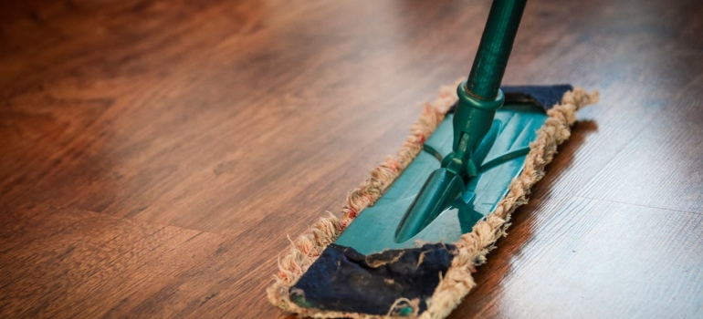 a brown wooden floor and broom